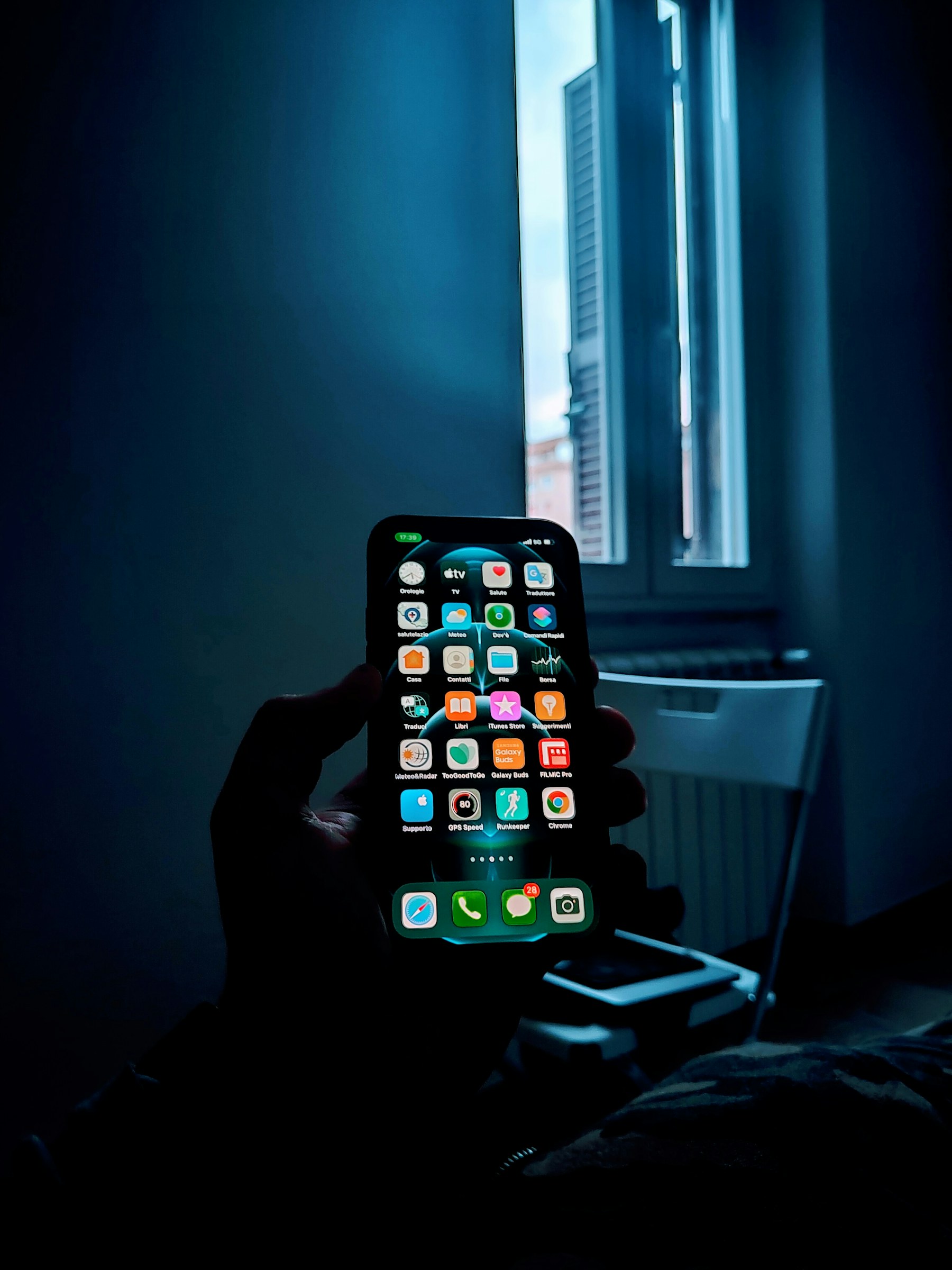Telefon sa svijetlim zaslonom u tamnijem prostoru